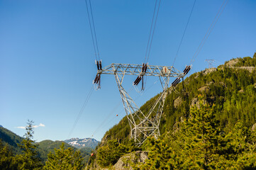 Power lines and tower passing through mountains.