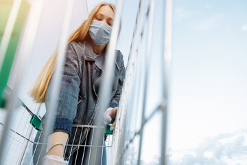 A woman in a medical mask buys groceries at a grocery store. Coronavirus, virus, infection, epidemic, pandemic. Russia