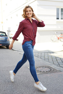 Portrait of happy woman crossing the street