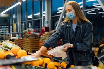 A woman in a medical mask buys groceries at a grocery store. Coronavirus, virus, infection, epidemic, pandemic. Russia