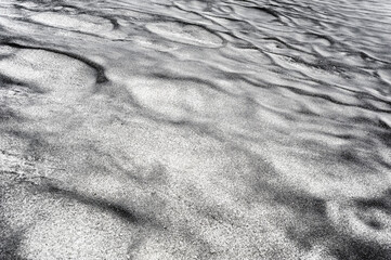 Abstract dirty black texture on white snow.