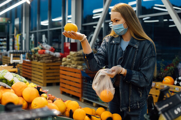 A woman in a medical mask buys groceries at a grocery store. Coronavirus, virus, infection, epidemic, pandemic. Russia