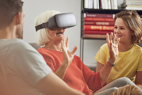 Grandmother using VR glasses with her grandsons