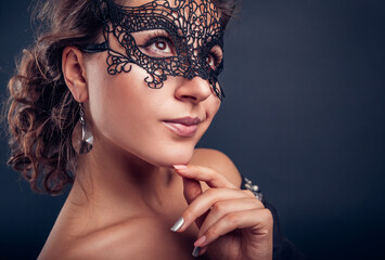 New year masquerade party. Beautiful young woman wearing lace carnival mask and jewellery. Fashion