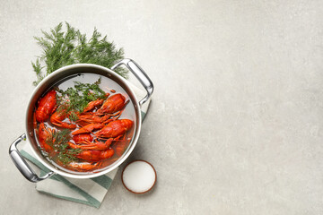 Fresh delicious crayfishes in pot on light grey table, flat lay. Space for text