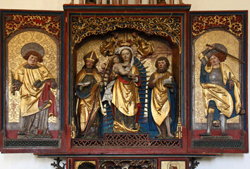 Madonna con Bambino tra San Mauro e San Giovanni Battista; ai lati, Santo Stefano e San Michele; altare scolpito nella chiesa di San Mauro presso Baselga di Pinè