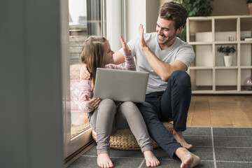 Young man and little girl surfing the net together