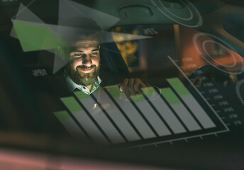 Smiling businessman with smartphone in car at night surrounded by data