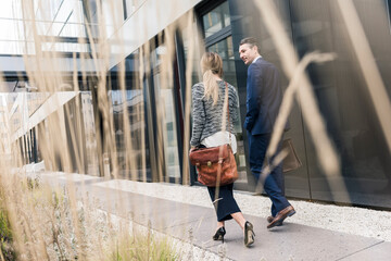 Businessman and woman walking outside office building