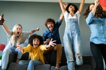 Excited fans watching tv and cheering