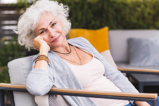 Thoughtful mature woman sitting at home