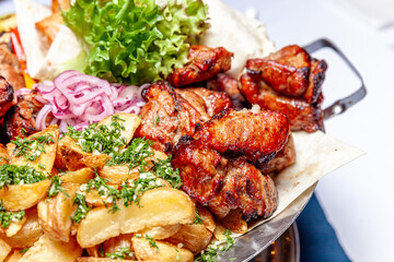 Mixed grill meat fried vegetables and grilled salmon fish fillets decoration in warm dish. Assorted delicious grilled kebab served with herbs on platter. Restaurant menu barbecue plate Bbq party meal