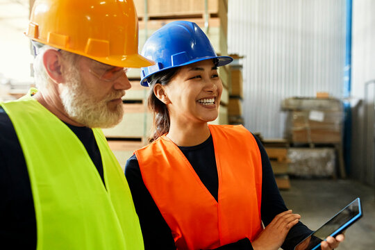 Male and female worker with tablet working together in factory