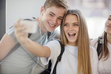 Happy students taking a selfie in school