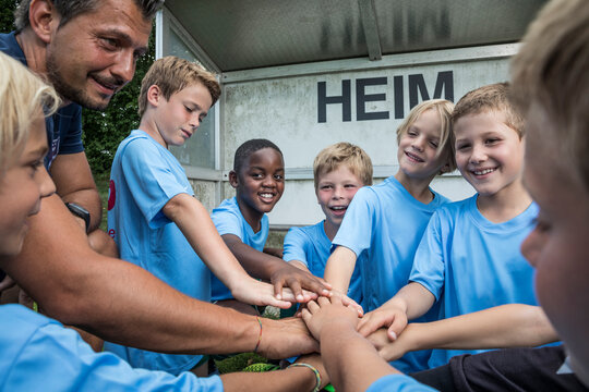 Coach and young football players huddling