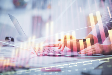 Double exposure of woman hands typing on computer and forex chart hologram drawing. Stock market...