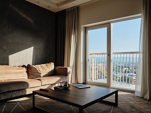 Coffee table with sunlight on empty sofa in luxury hotel room