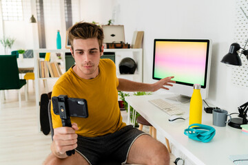 Fitness trainer showing computer during live streaming at home