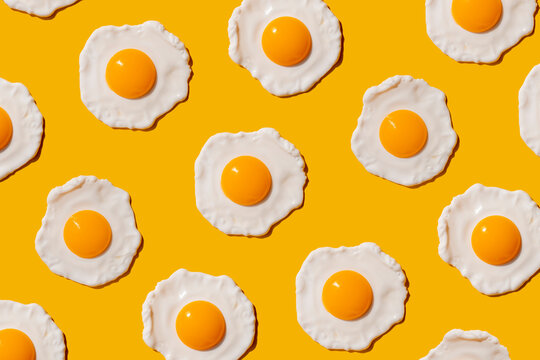 Pattern of fried eggs against yellow background