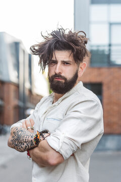 Confident hipster man standing with arms crossed in city