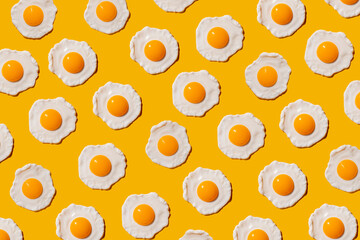 Pattern of fried eggs against yellow background