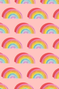 Multiple image of semi-circle wooden rainbow toys on pink background