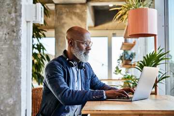 Mature man doing freelance work while sitting at home