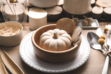 Autumn table setting with pumpkin and decor on wooden background