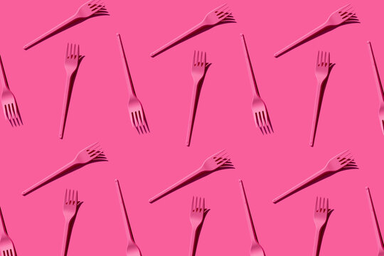 Pattern of pink plastic forks against pink background