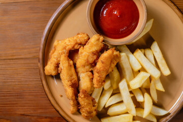 Chicken nuggets with fries and ketchup close-up.