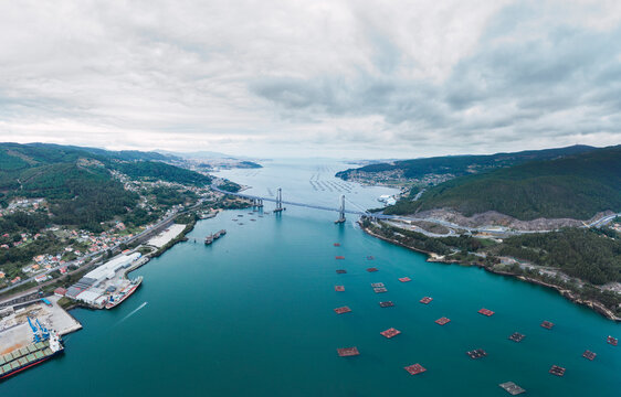 Aerial view of fish farm near Rande Bridge against cloudy sky, Vigo, Pontevedra Province, Galicia, Spain