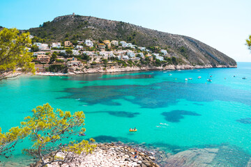 Summer at beautiful El Portet Beach with crystal clear turqouise waters in Moraira, Costa Blanca,...