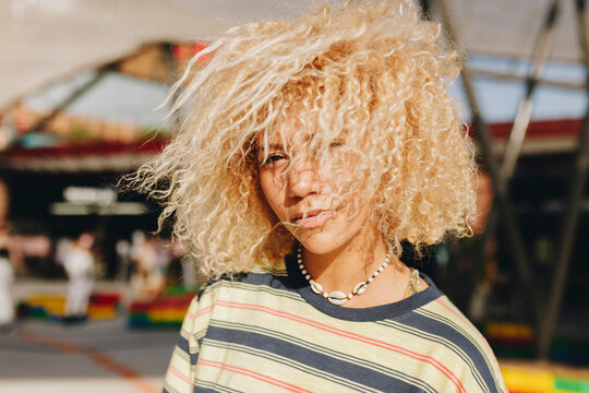 Confident blond Afro woman standing outdoors on sunny day