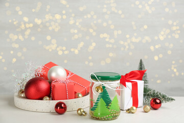 Handmade snow globe and Christmas decorations on light table, space for text