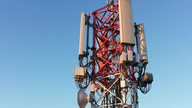 Telecommunications tower carrying broadcasting antennas for 3G, 4G and 5G cellular networks. Aerial view of a tall metal construction with equipment for mobile telephony transmission and internet.
