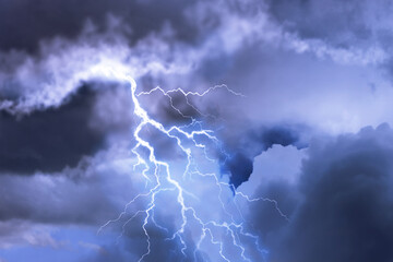 Naklejka na ściany i meble Lightning in dark cloudy sky during thunderstorm