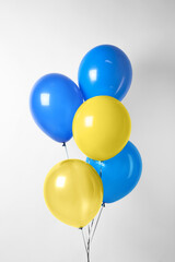 Many balloons in colors of Ukrainian flag on light background