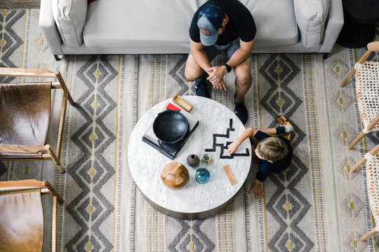 Dad and son playing dominos in the living room of a modern home