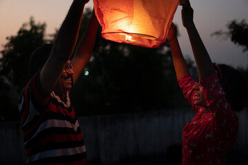 Father and daughter releasing Chinese lantern at night