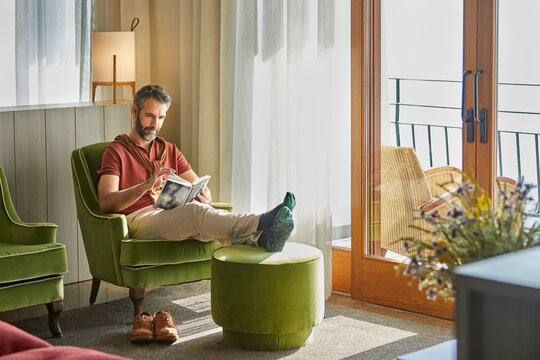 Man sitting in the armchair reading