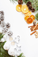 Christmas, winter, new year composition. Fir tree branches, pine cone, candles, cinnamon sticks, dried oranges, gingerbread on white background. Flat lay, top view, copy space