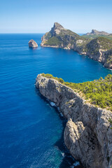View of a rocky cliff on a sunny day in Formentor cape in Palma de Mallorca, Balearic Islands, Spain, verical