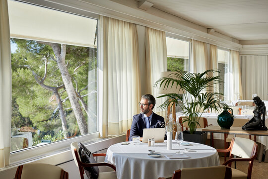 Businessman looking through the window in the restaurant