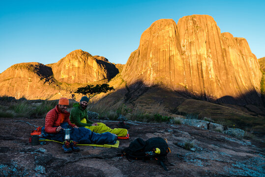 Two montaneers having a coffee at fisrt our in the morning after bivouaking under the stars
