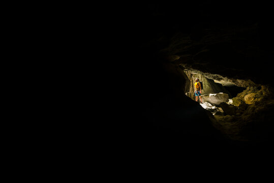 Traveler standing in dark cave