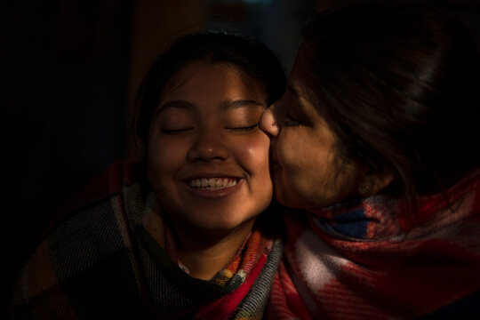 Mother kissing her Daughter inside home