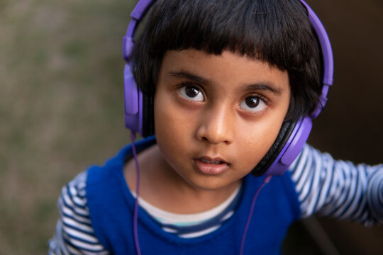 Little cute girl listening music with headphone