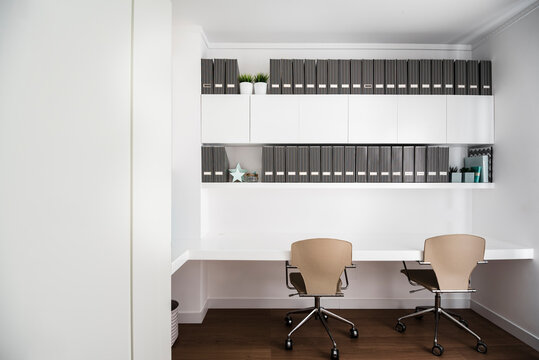 Minimalistic home office in a flat with two chairs and sort folders