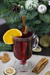 winter treats, a mug of warm wine with an orange, and cookies, ingredients on a wooden brown table. Traditional hot drink for Christmas, in the background Christmas composition