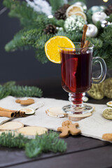 winter treats, a mug of warm wine with an orange, and cookies, ingredients on a wooden brown table....